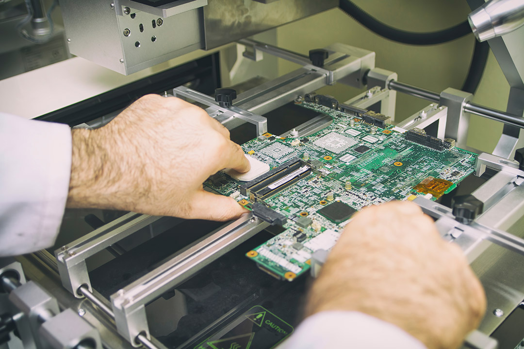 Una boquilla de una máquina automatizada de colocación de componentes SMT posiciona con precisión un chip BGA de gran tamaño sobre una placa de circuito impreso personalizada dentro de una línea de producción de ensamblaje BGA de alta velocidad.