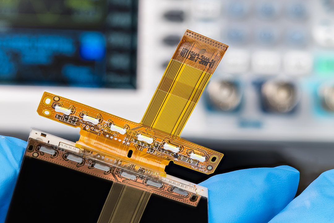 Técnico cualificado manejando una máquina de montaje superficial totalmente automatizada (SMT) para la colocación de componentes, posicionando con precisión los componentes sobre un sustrato de PCB flexible durante un proceso de ensamblaje de alta velocidad en las instalaciones especializadas de sala limpia de LHD TECH.